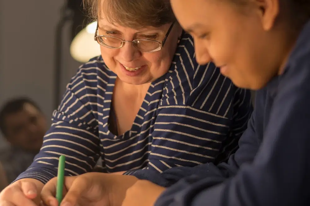 carer teaching young adult to write